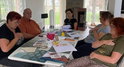 Groupe de participants assis autour d'une table, cartes et documents étalés, dans une atmosphère de travail et d'échange.